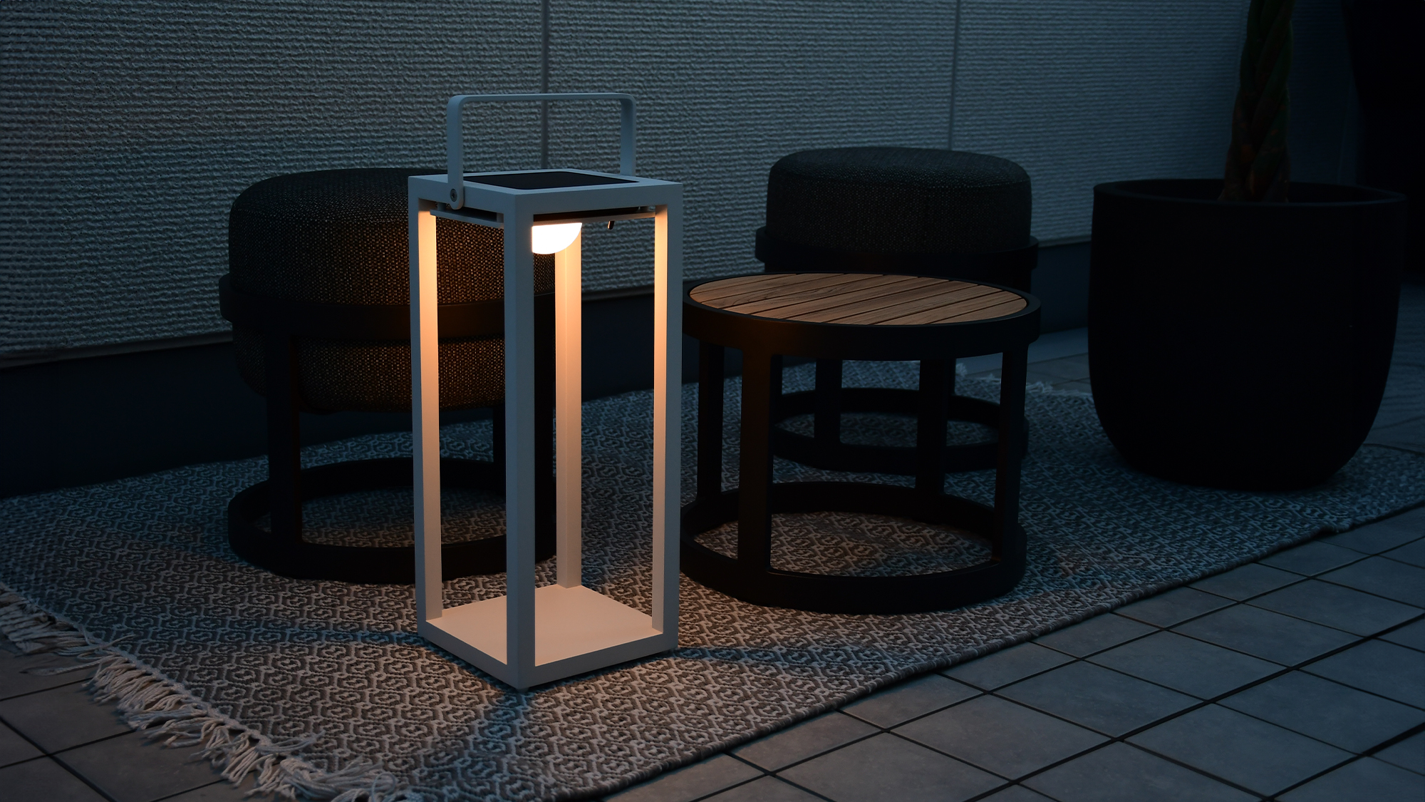 じゅうたんを敷いたベランダにテーブルセットを置いて、リヒトルクスフロアホワイトを灯している空間