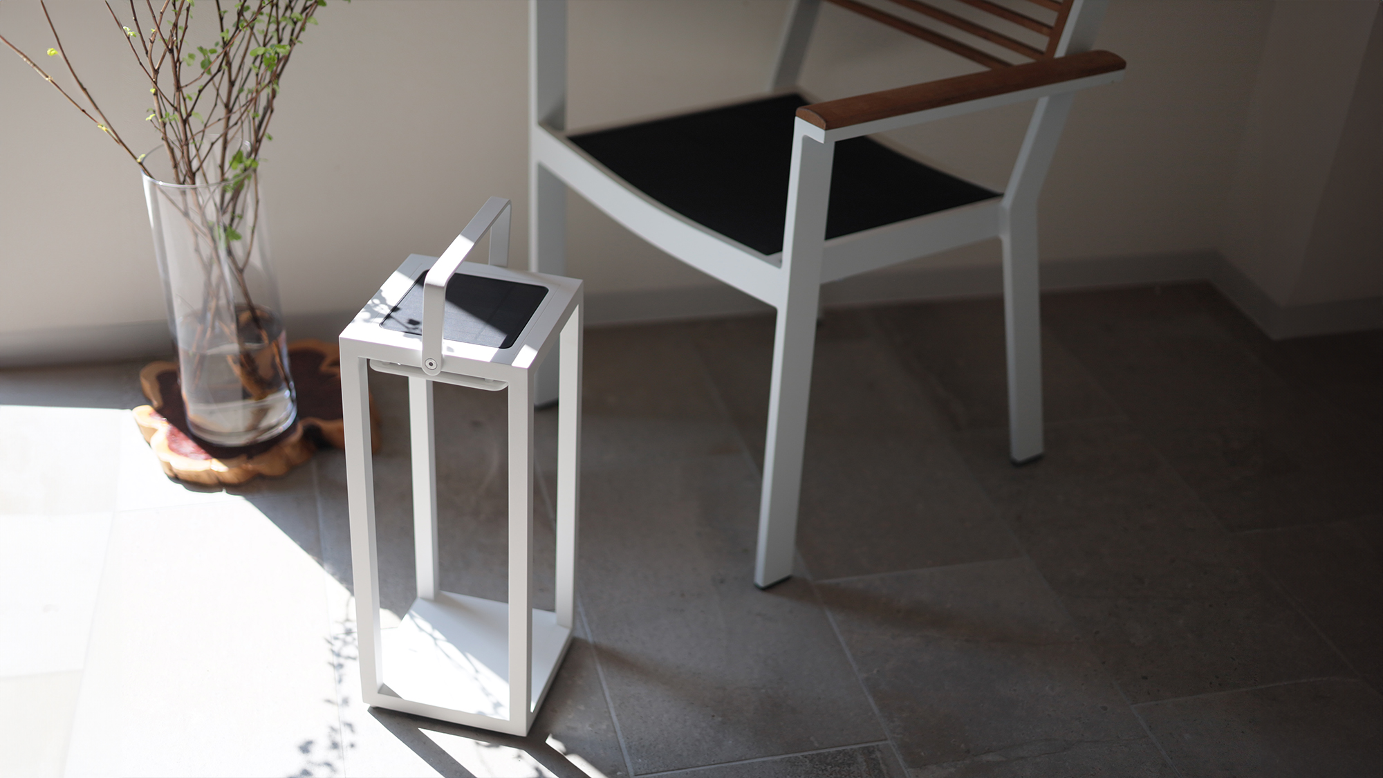 日が差し込む窓際で、花瓶に飾られている高木の枝の葉の影がリヒトルクスフロアホワイトに落ちている